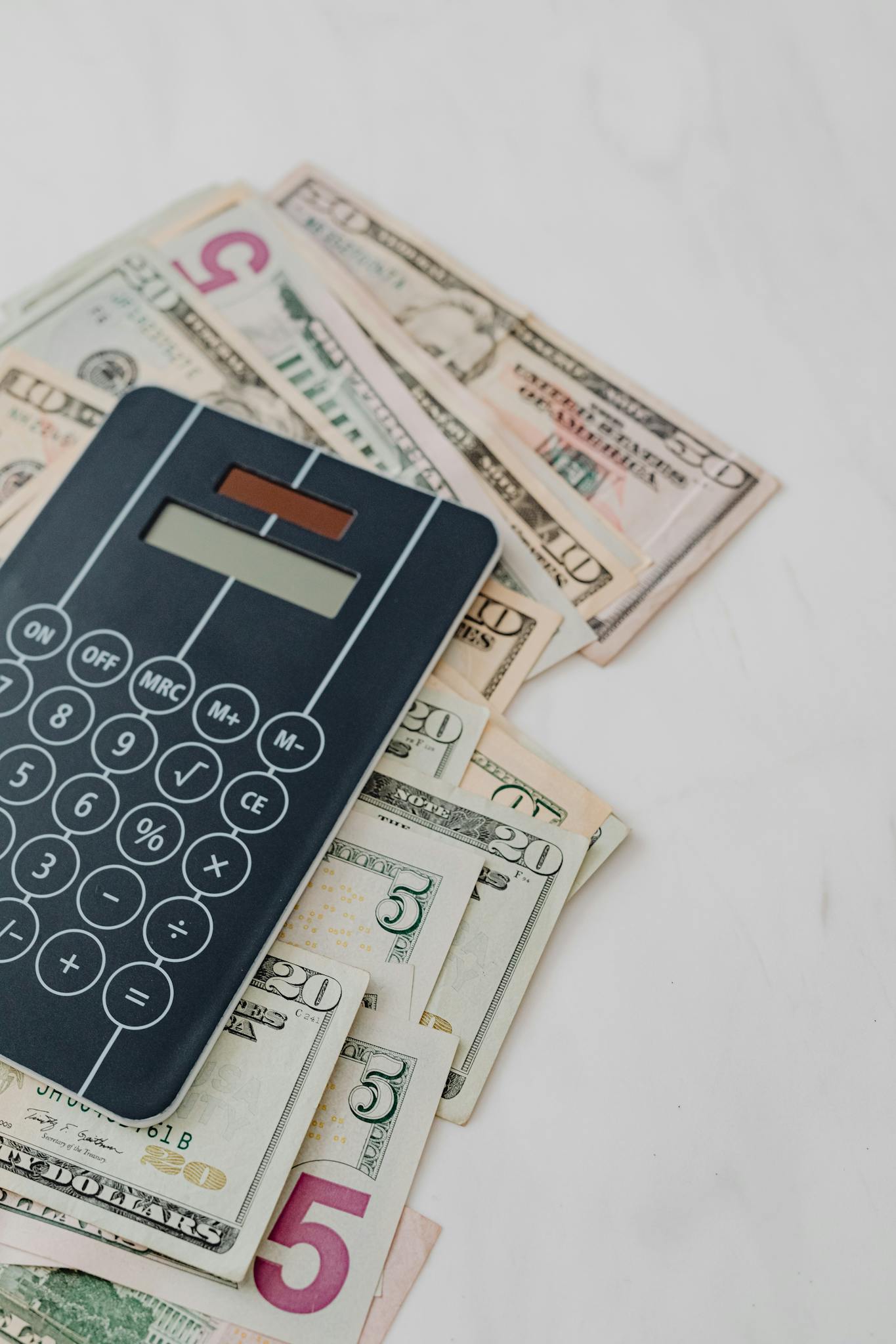 Calculator and US dollar banknotes, symbolizing finance and budgeting.
